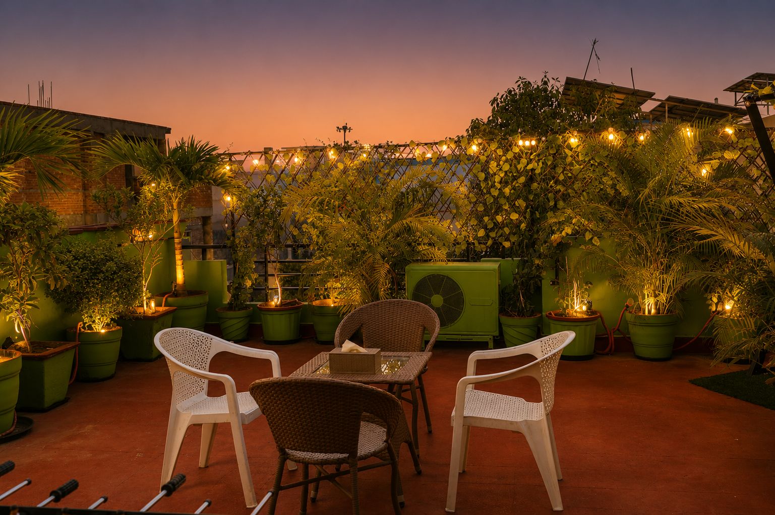 Rooftop terrace at dusk with lanterns, palms and seating