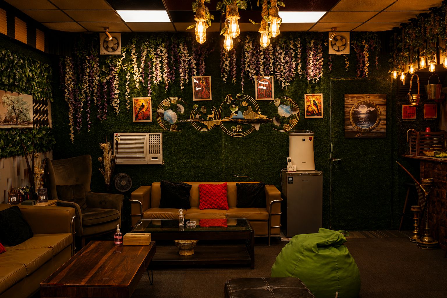 Lounge with sofas, green wall and pendant lights